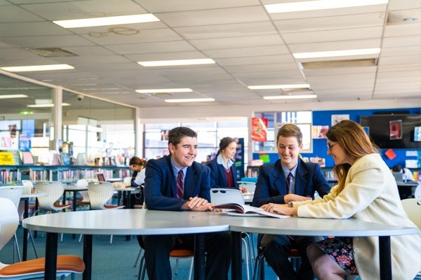 St Patrick's College Sutherland - teacher and students looking at a booklet